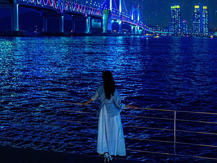 在夜海上观看无人机秀的游客