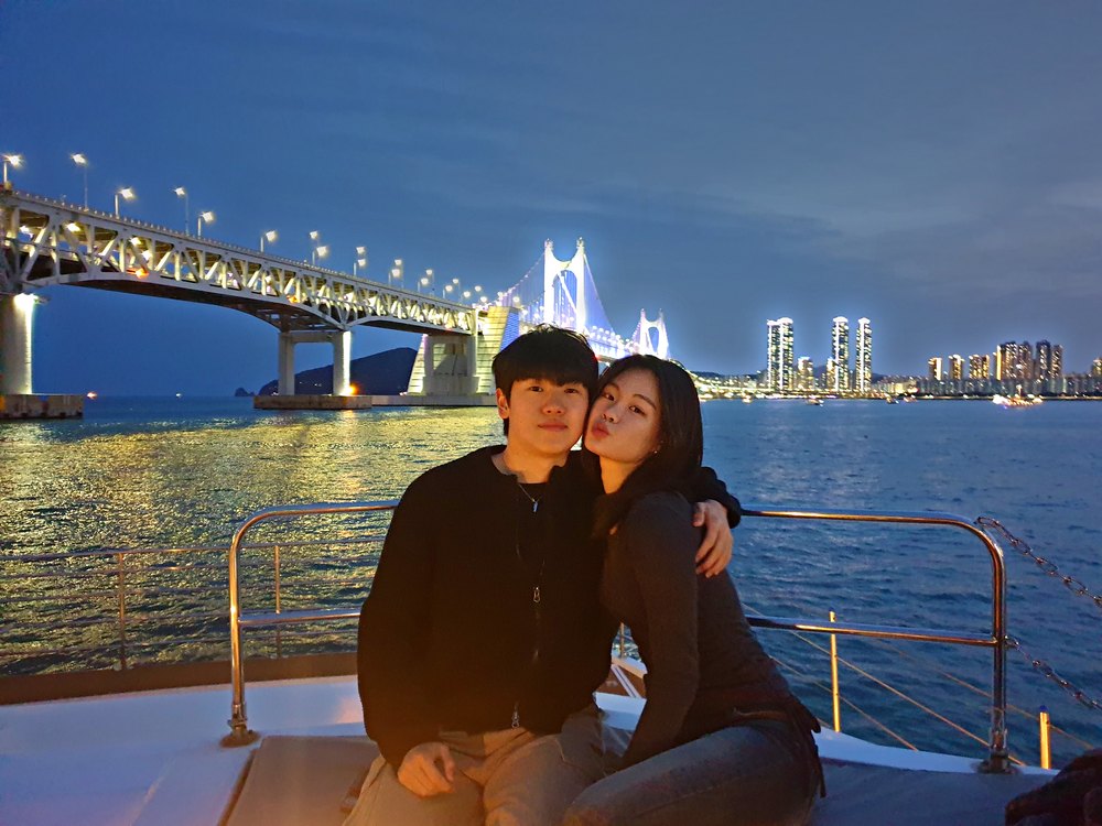 广安大桥夜景前游船甲板上的情侣